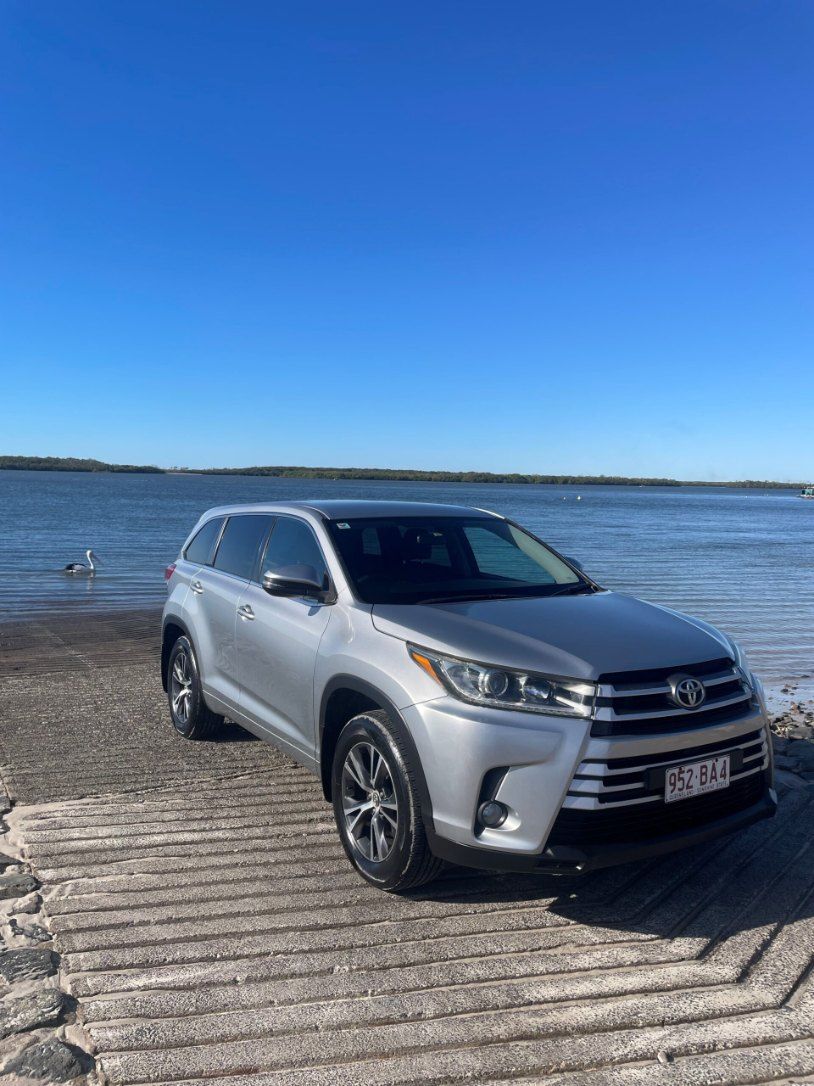 A Silver Toyota Highlander is Parked on a Wooden Ramp Next to a Body of Water — Pelican Motors Service Centre In Caloundra West, QLD 