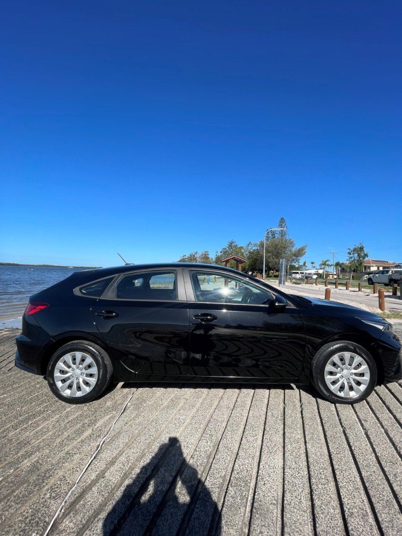 A Black Car is Parked on a Wooden Dock Next to a Body of Water — Pelican Motors Service Centre In Caloundra West, QLD 