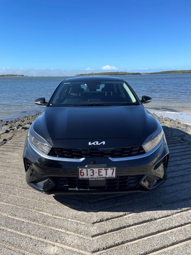 A Black Car is Parked on a Beach Next to a Body of Water — Pelican Motors Service Centre In Caloundra West, QLD 