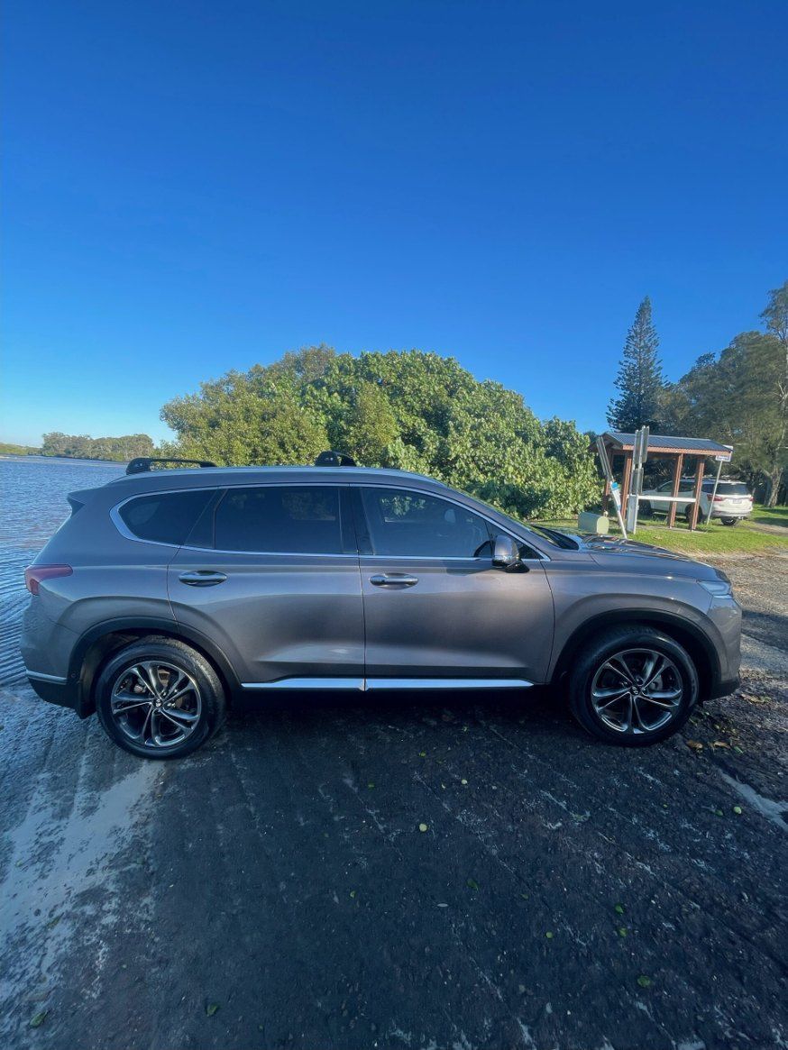 A Gray Suv is Parked on the Side of a Road Next to a Body of Water — Pelican Motors Service Centre In Caloundra West, QLD 