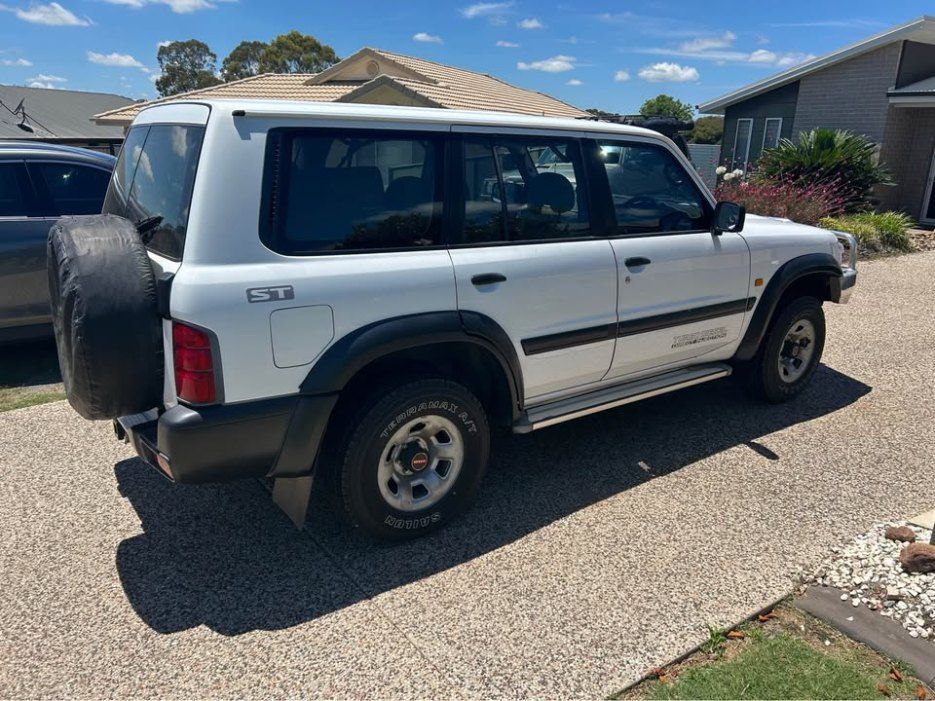 A White Suv is Parked on a Gravel Driveway in Front of a House — Pelican Motors Service Centre In Caloundra West, QLD 