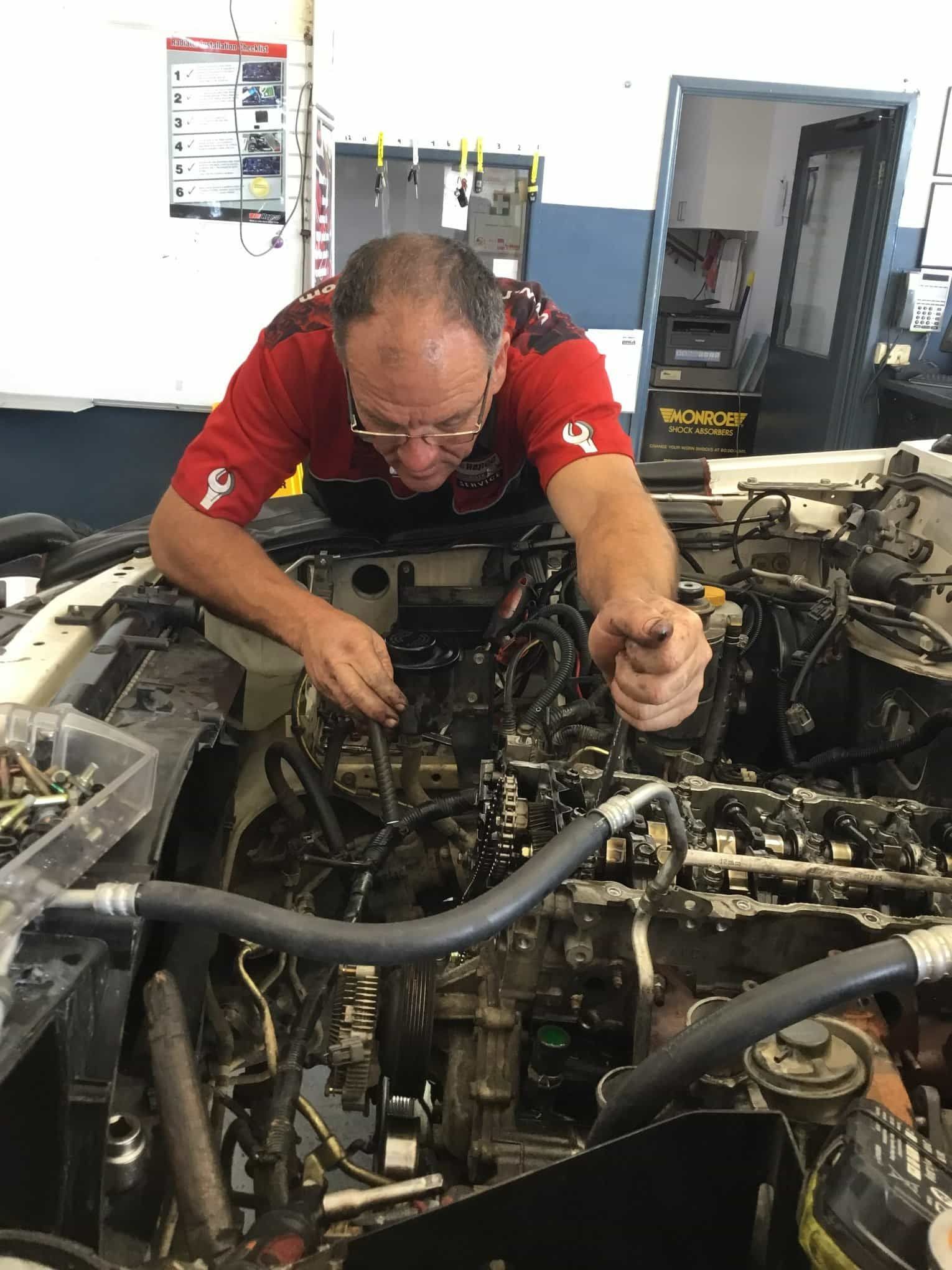 A Man is Working on a Car Engine in a Garage — Pelican Motors Service Centre In Caloundra West, QLD