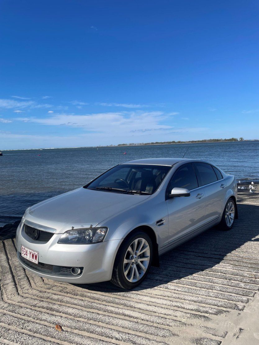 A Silver Car is Parked on a Dock Next to the Ocean — Pelican Motors Service Centre In Caloundra West, QLD 