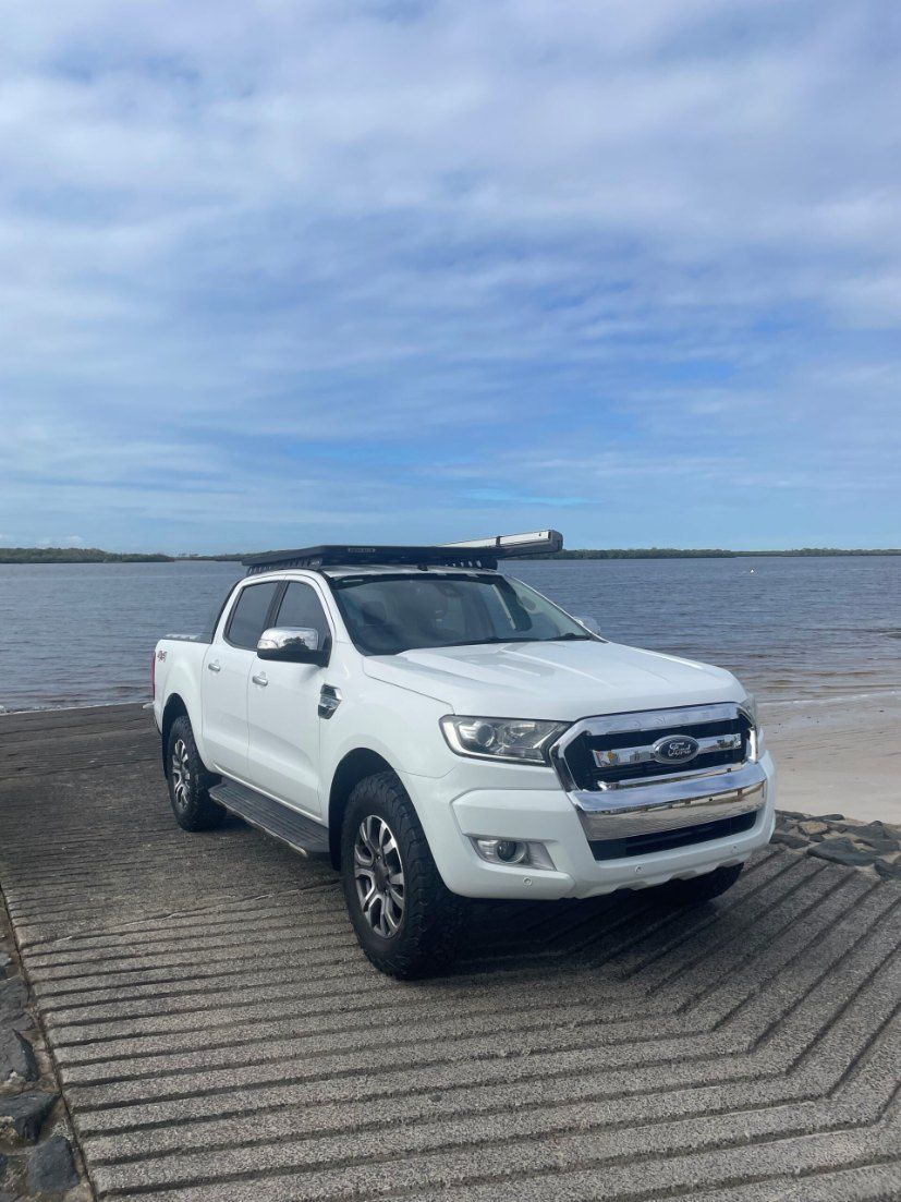A White Ford Ranger is Parked on a Dock Next to a Body of Water — Pelican Motors Service Centre In Caloundra West, QLD 