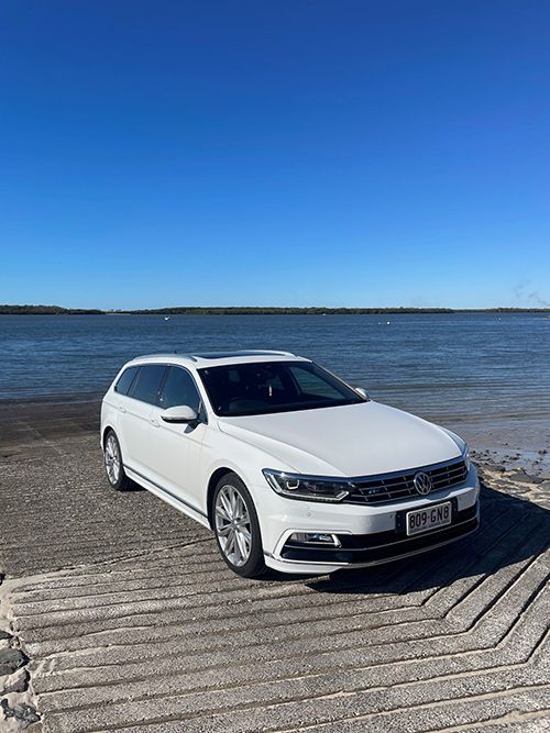 A White Car is Parked on a Dock Next to a Body of Water — Pelican Motors Service Centre In Caloundra West, QLD 