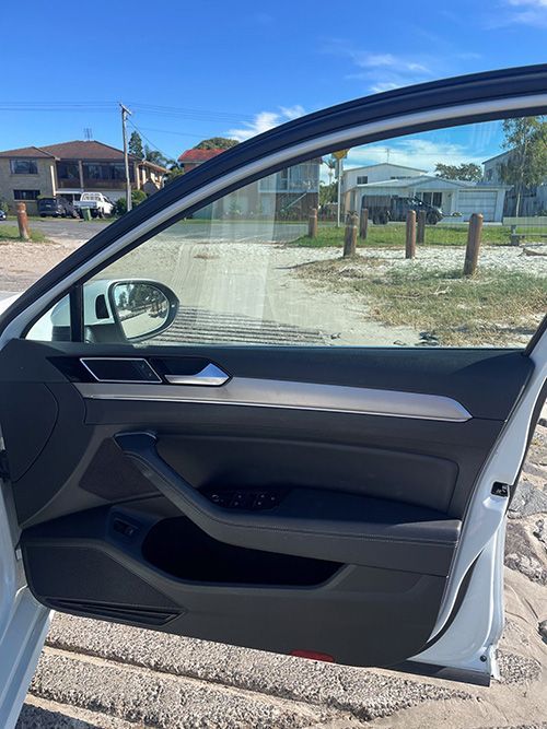 A White Car is Parked on the Beach With the Door Open — Pelican Motors Service Centre In Caloundra West, QLD 