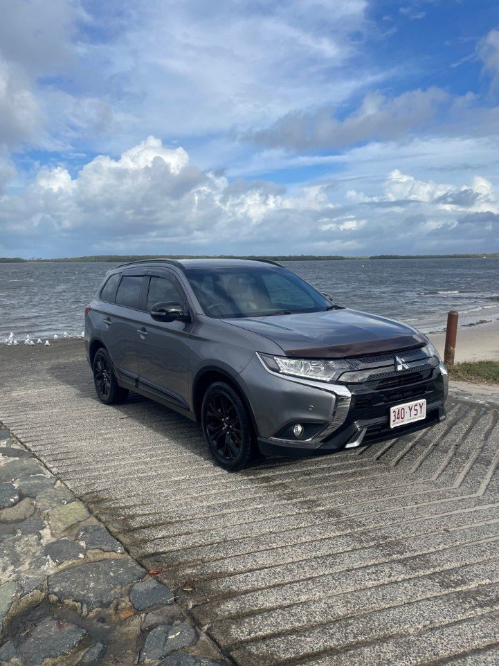 A Mitsubishi Outlander is Parked on a Concrete Ramp Next to the Ocean — Pelican Motors Service Centre In Caloundra West, QLD 