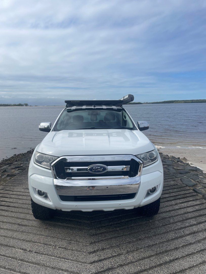 A White Ford Ranger is Parked on a Sandy Beach Next to a Body of Water — Pelican Motors Service Centre In Caloundra West, QLD 