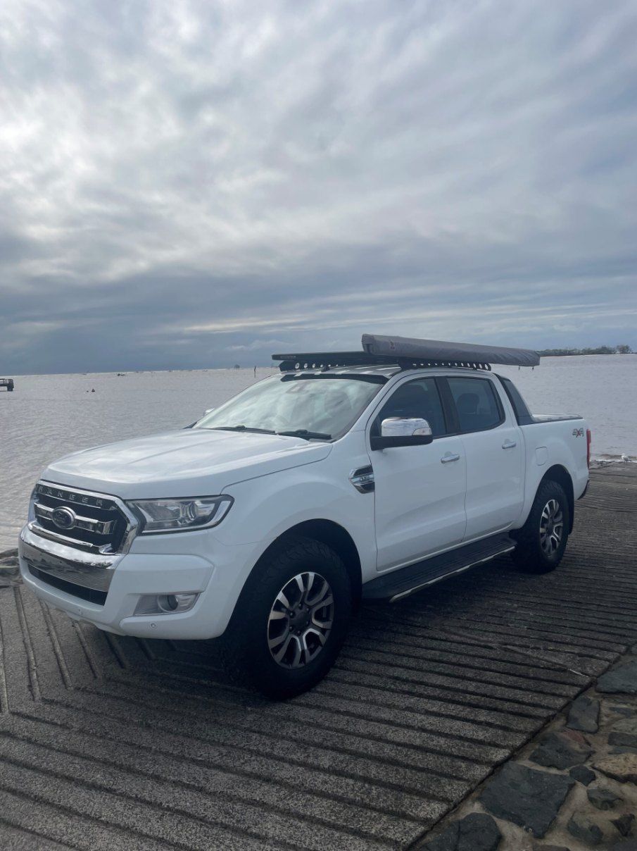A White Truck With a Canopy on Top of It is Parked Next to a Body of Water — Pelican Motors Service Centre In Caloundra West, QLD 