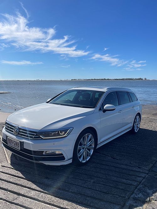 A White Car is Parked on the Beach Next to the Water — Pelican Motors Service Centre In Caloundra West, QLD 