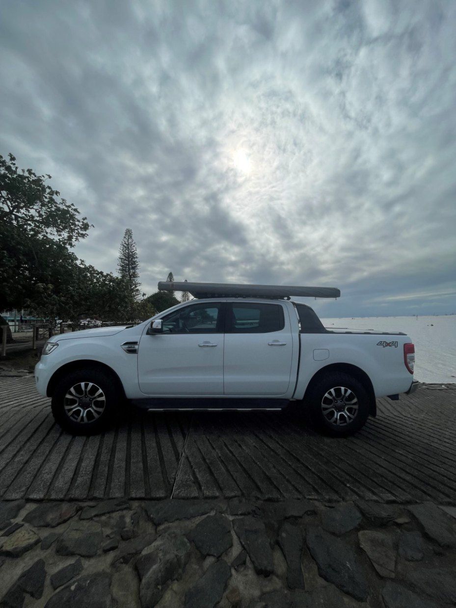 A White Truck With an Awning on Top of It is Parked on a Beach — Pelican Motors Service Centre In Caloundra West, QLD 