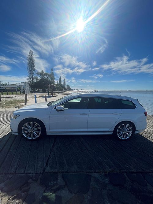 A White Car is Parked on a Wooden Dock Next to the Ocean — Pelican Motors Service Centre In Caloundra West, QLD 