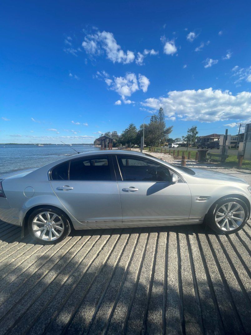 A Silver Car is Parked on a Wooden Dock Next to a Body of Water — Pelican Motors Service Centre In Caloundra West, QLD 