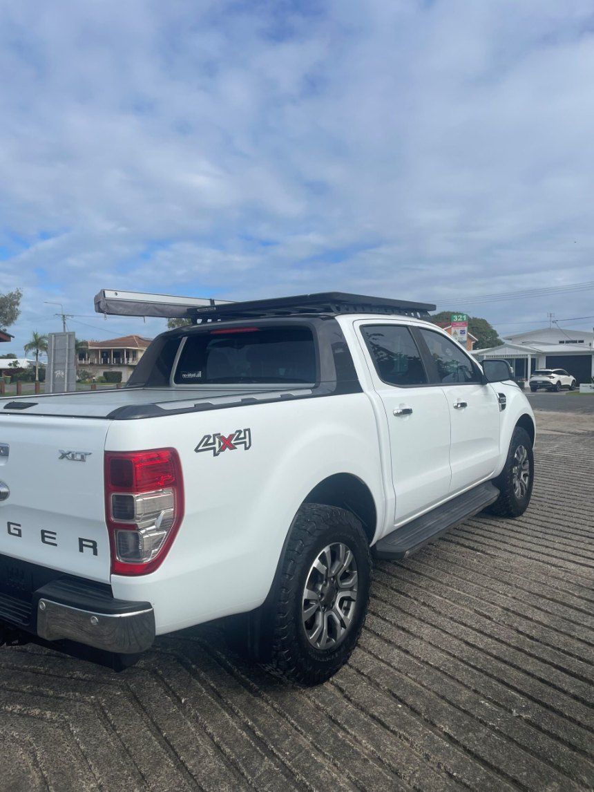 A White Truck With a Roof Rack on Top of It is Parked in a Parking Lot — Pelican Motors Service Centre In Caloundra West, QLD 