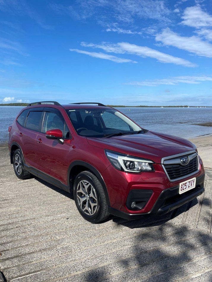 A Red Subaru Forester is Parked Next to a Body of Water — Pelican Motors Service Centre In Caloundra West, QLD 
