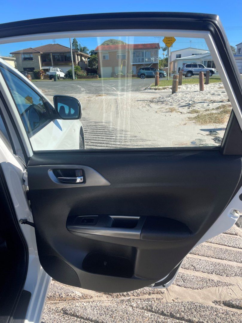 A White Car is Parked on the Beach With the Door Open — Pelican Motors Service Centre In Caloundra West, QLD 