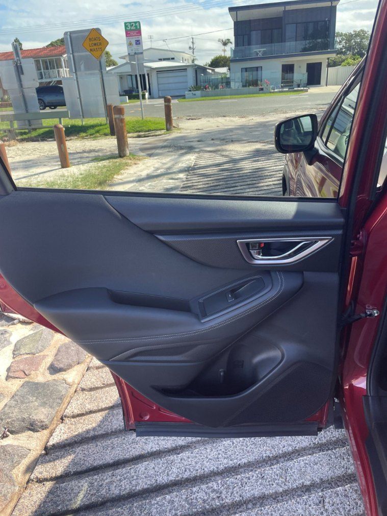 A Red Car is Parked on the Side of the Road With the Door Open — Pelican Motors Service Centre In Caloundra West, QLD 