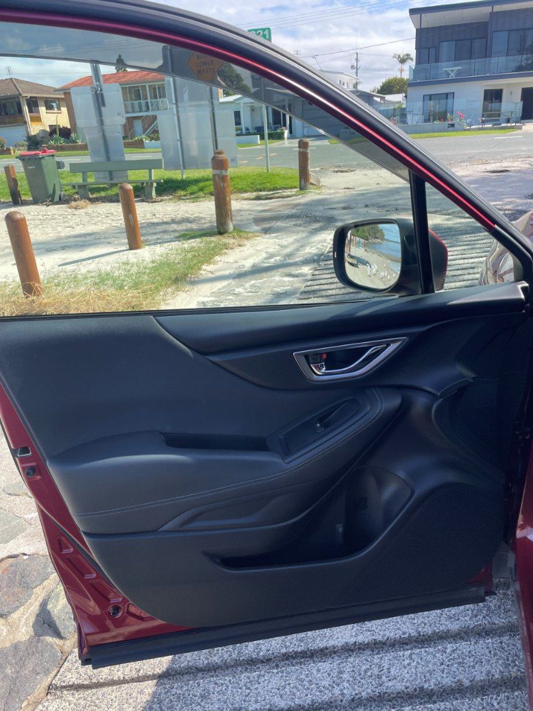 A Red Car is Parked on the Side of the Road With the Door Open — Pelican Motors Service Centre In Caloundra West, QLD 