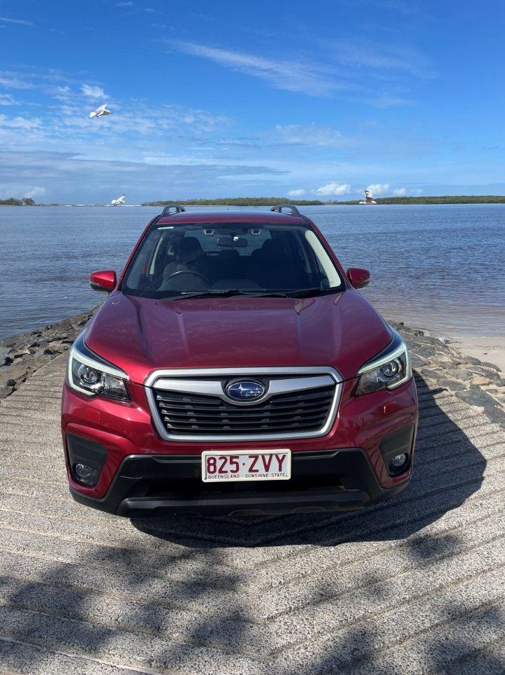 A Red Subaru Forester is Parked Next to a Body of Water — Pelican Motors Service Centre In Caloundra West, QLD 