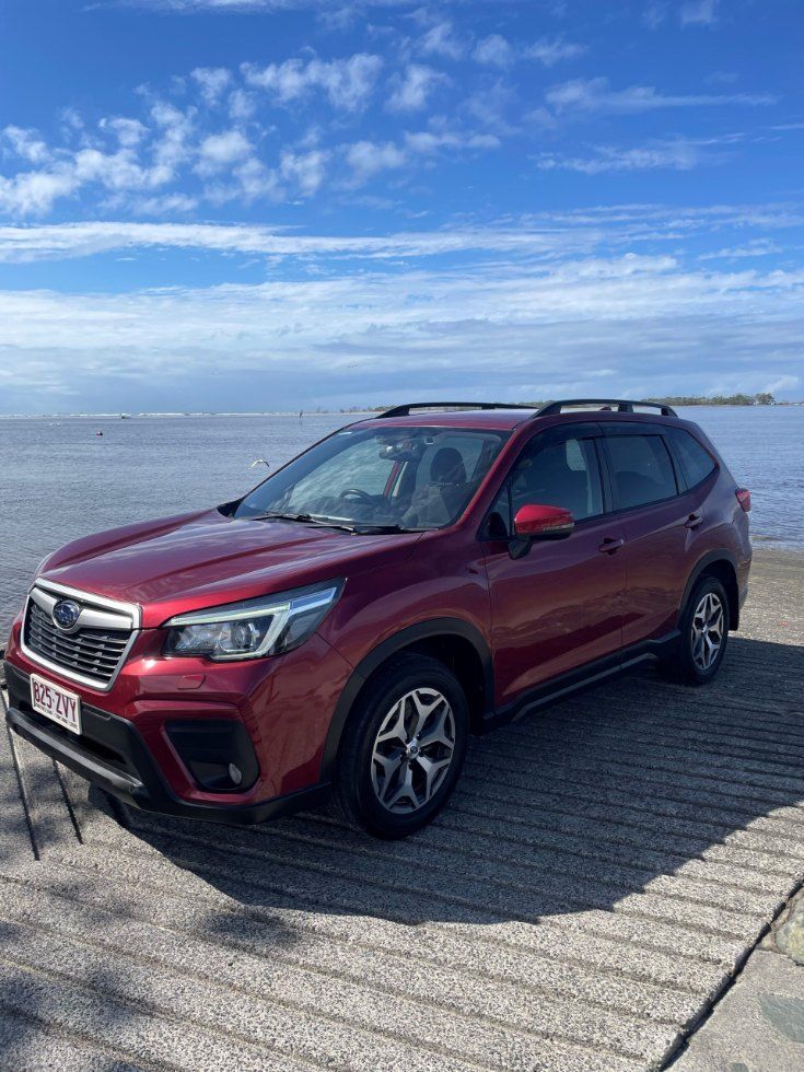 A Red Subaru Forester is Parked on a Dock Next to the Ocean — Pelican Motors Service Centre In Caloundra West, QLD 