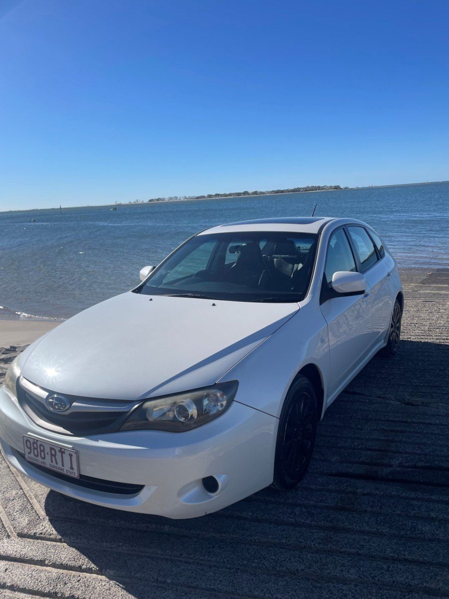 A White Car is Parked on the Beach Near the Water — Pelican Motors Service Centre In Caloundra West, QLD 
