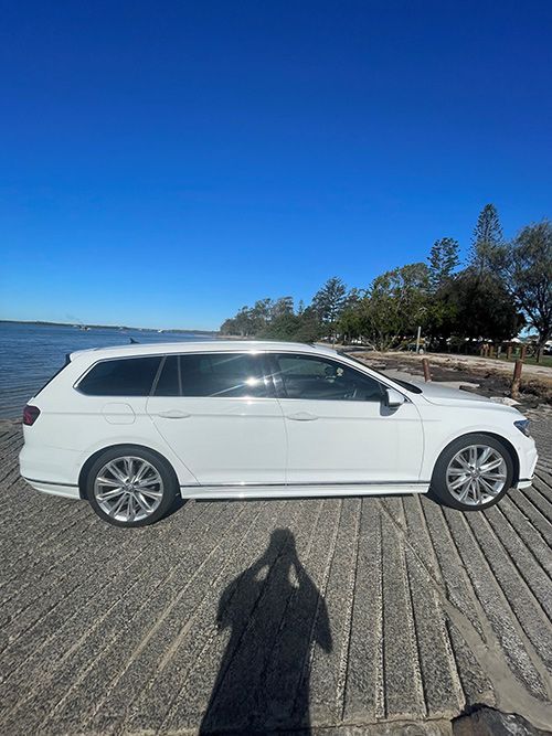 A White Car is Parked on a Dock Next to a Body of Water — Pelican Motors Service Centre In Caloundra West, QLD 