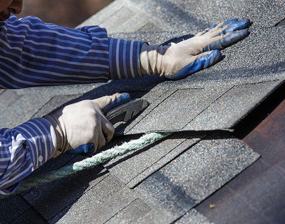Worker Cutting Shingle — Lakeport, CA — Lucerne Roofing & Supply Corp
