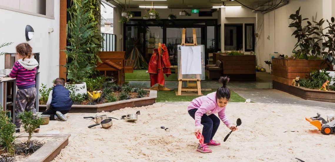 a group of children are playing in a sandbox .