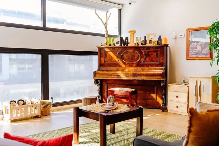 a living room with a piano and a coffee table
