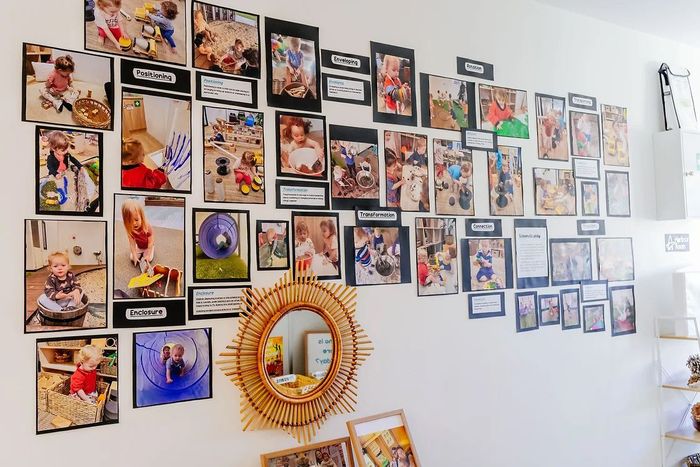 a wall filled with lots of pictures of children and a mirror .
