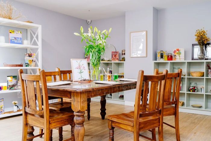 a dining room with a wooden table and chairs .