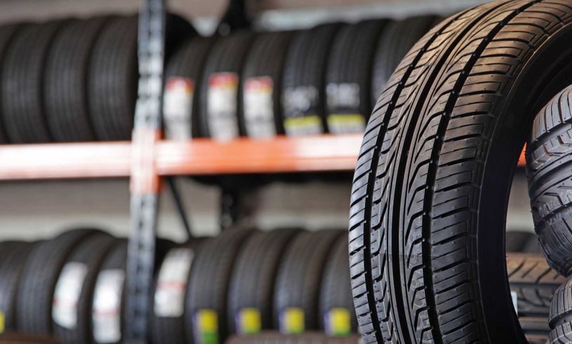A tire is sitting on top of a stack of tires.