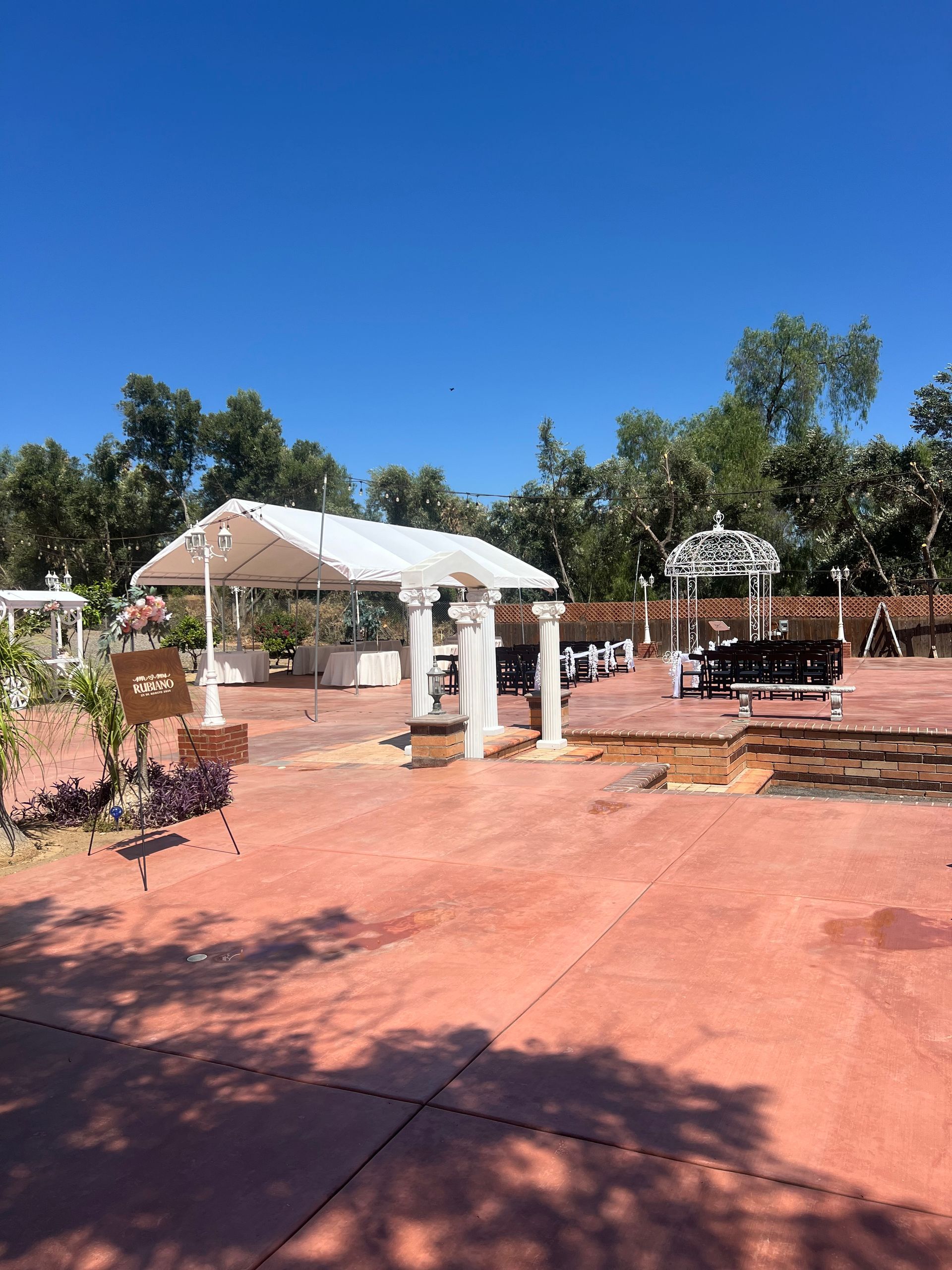 A large outdoor area with a white tent and trees in the background.