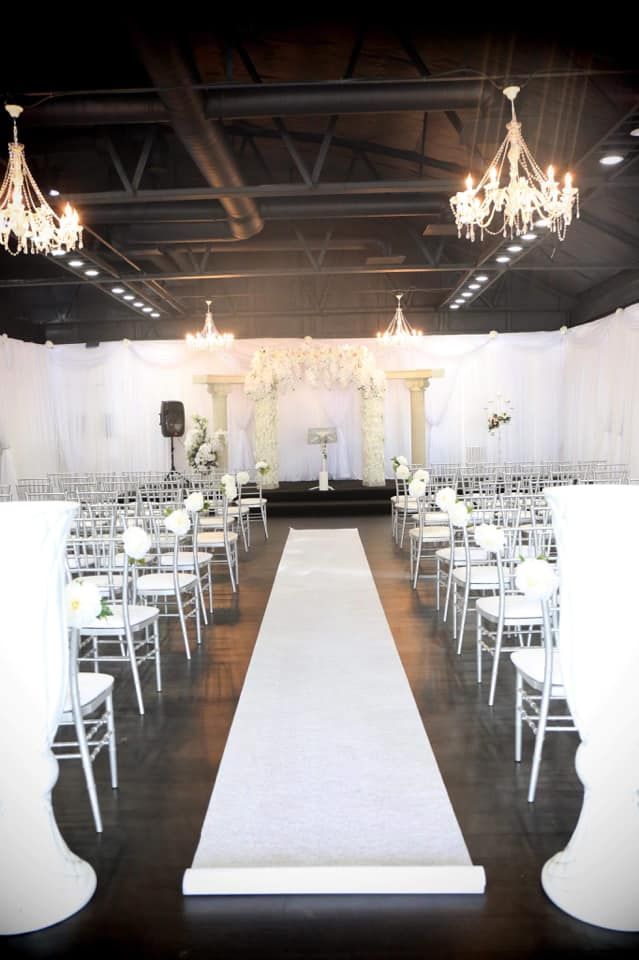 A large room with white chairs and a white aisle