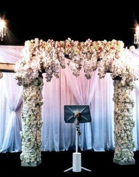 A stage decorated with white flowers and a podium.
