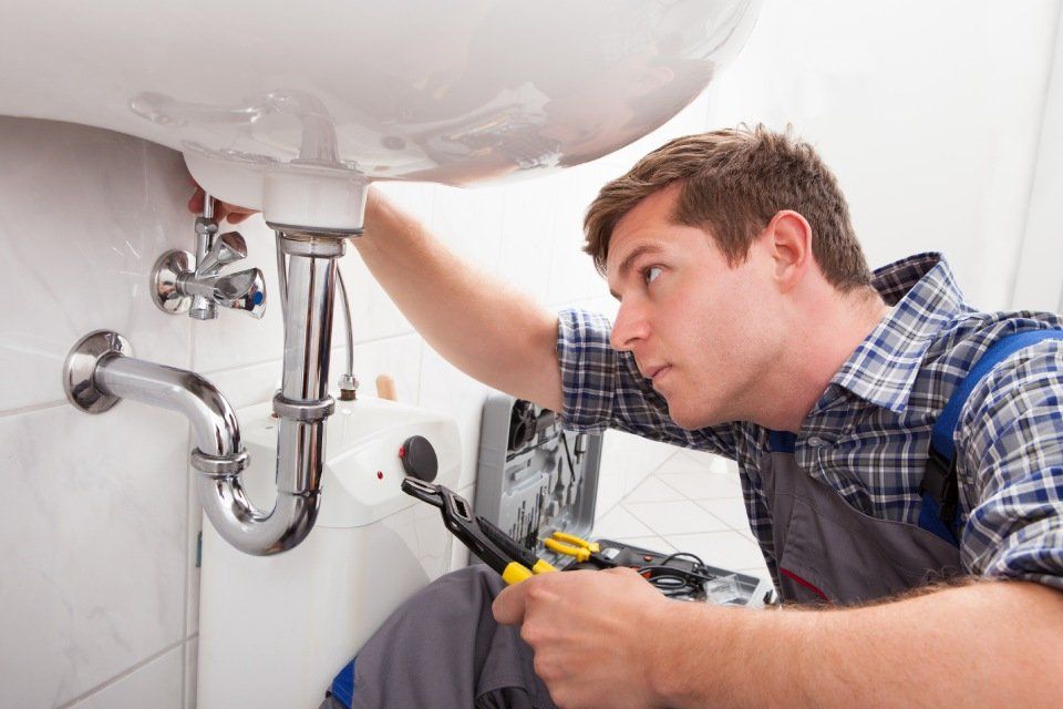 Plumber fixing water leakage on wash basin