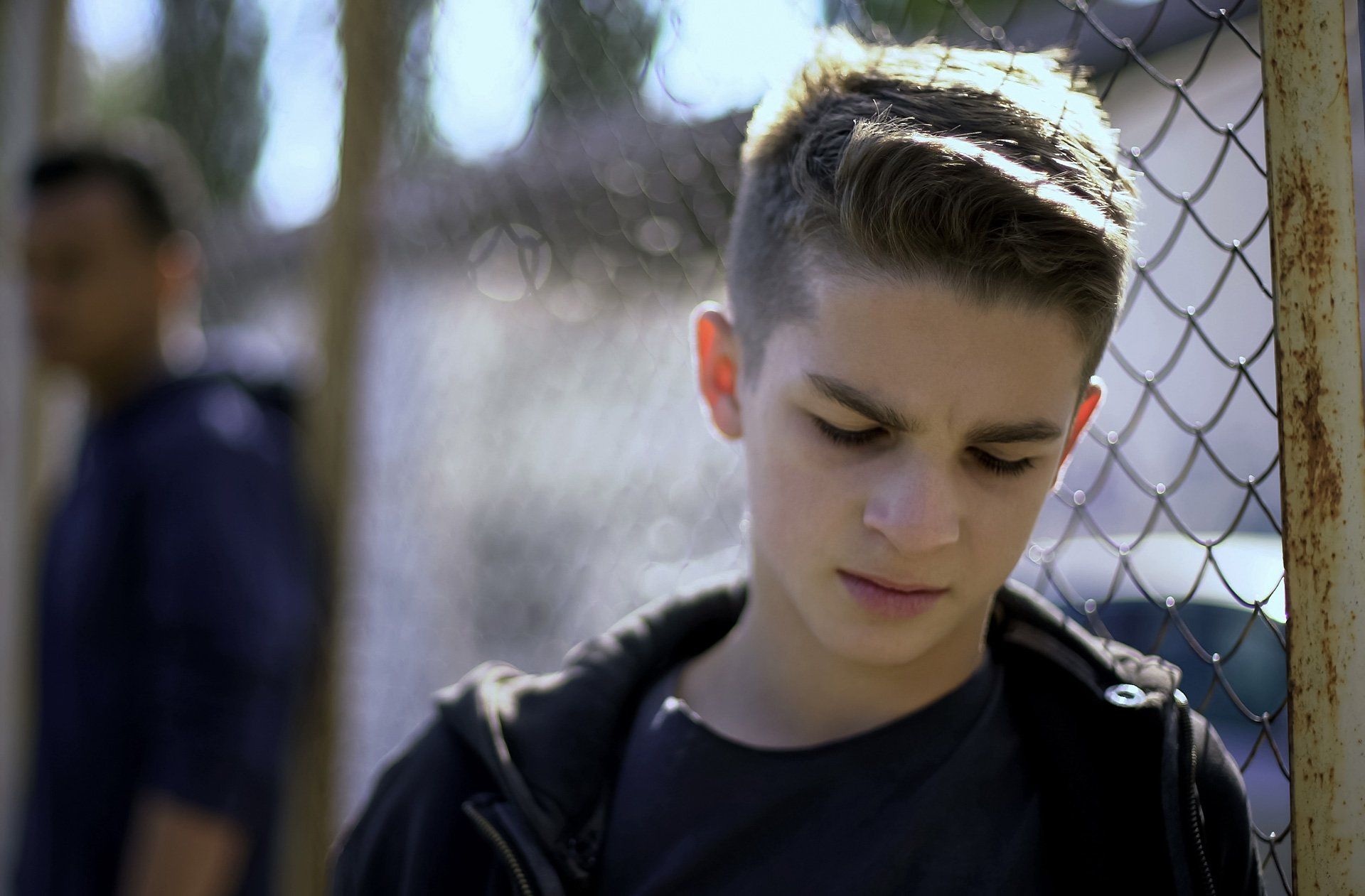 Dependency Court — Upset Teen Boy Leaning on Metal Fence in Bakersfield, CA