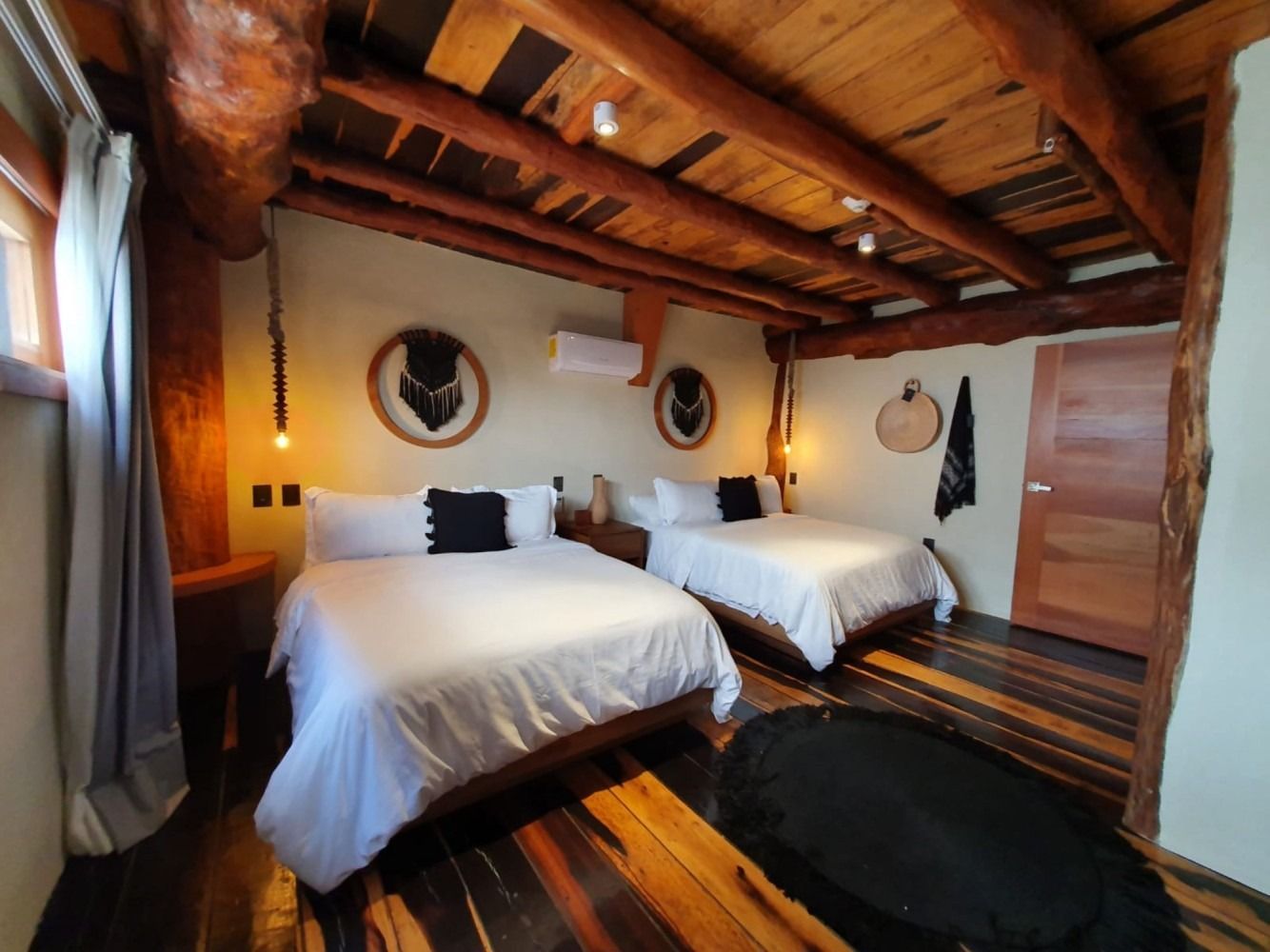 Bedroom with two beds, wood beams, and rustic decor.