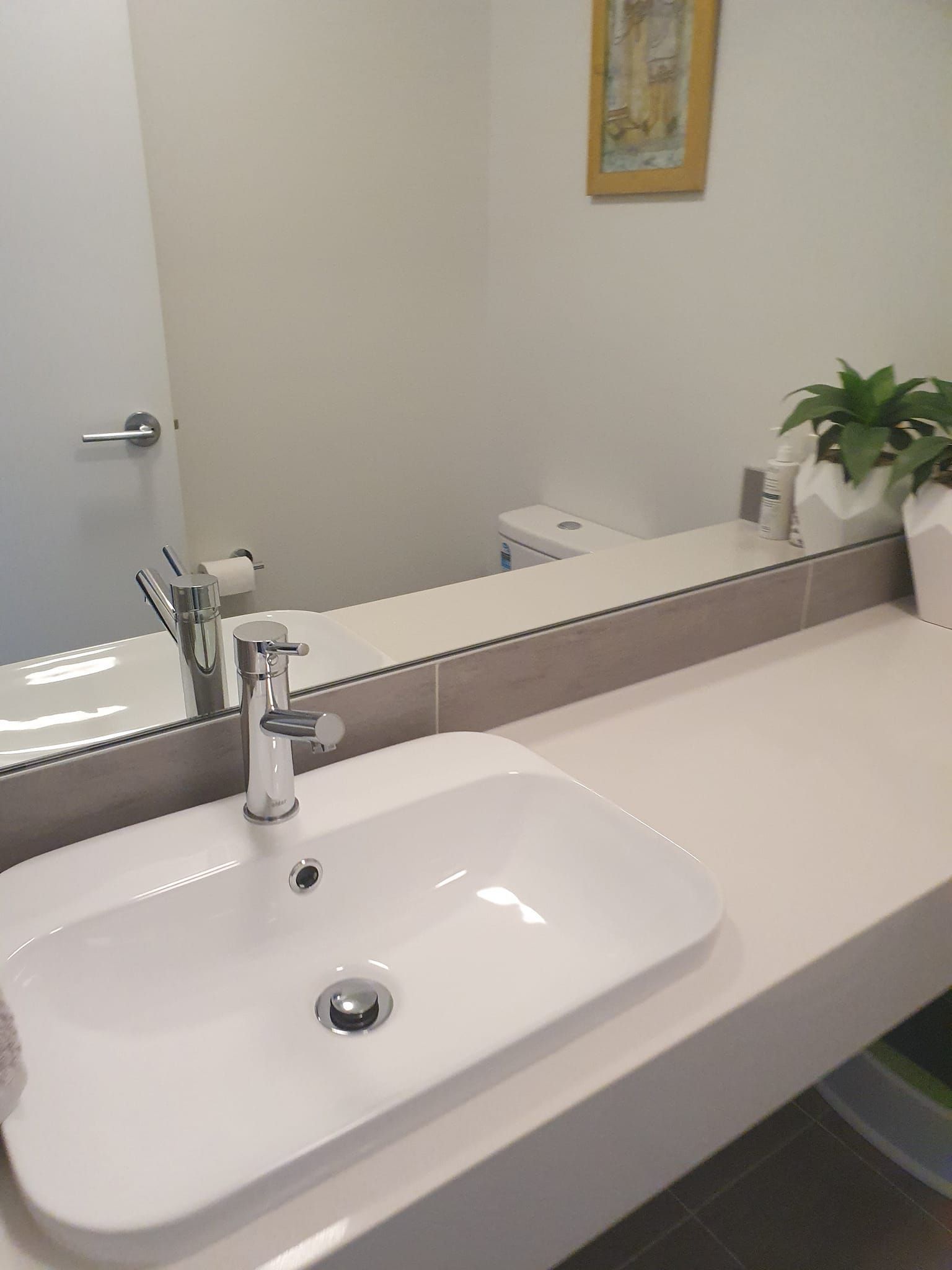 A Bathroom With a Sink, Mirror and Toilet — A Place 2 Shine In Chisholm, NSW