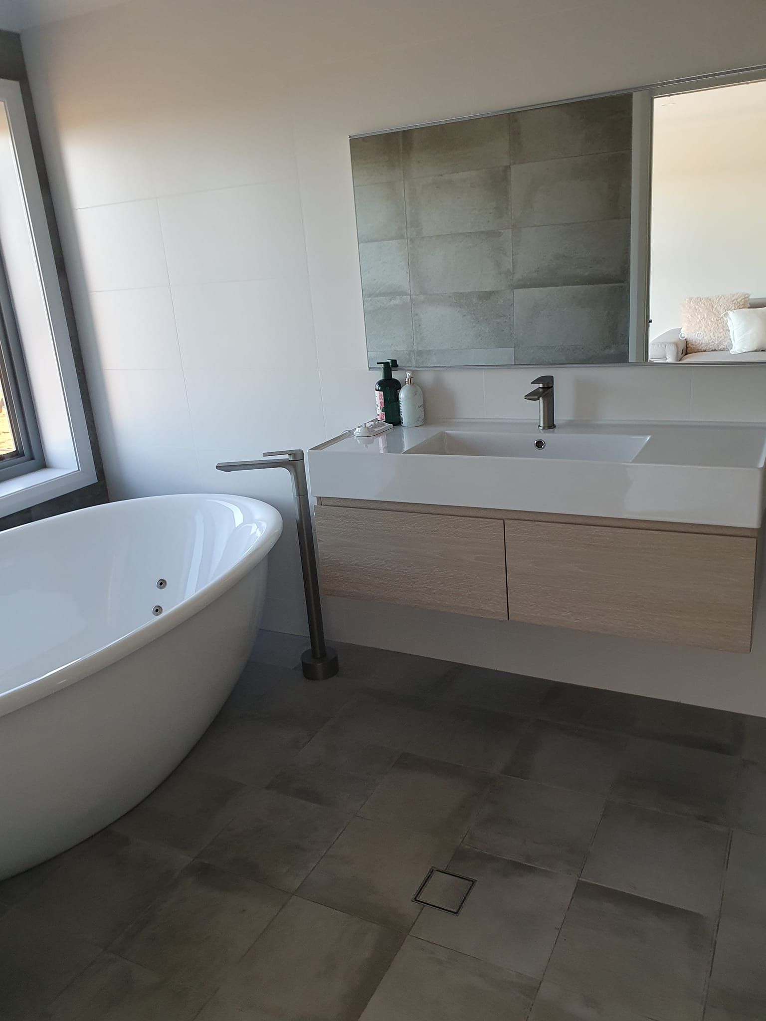 A Bathroom With a Bathtub , Sink and Mirror — A Place 2 Shine In Chisholm, NSW