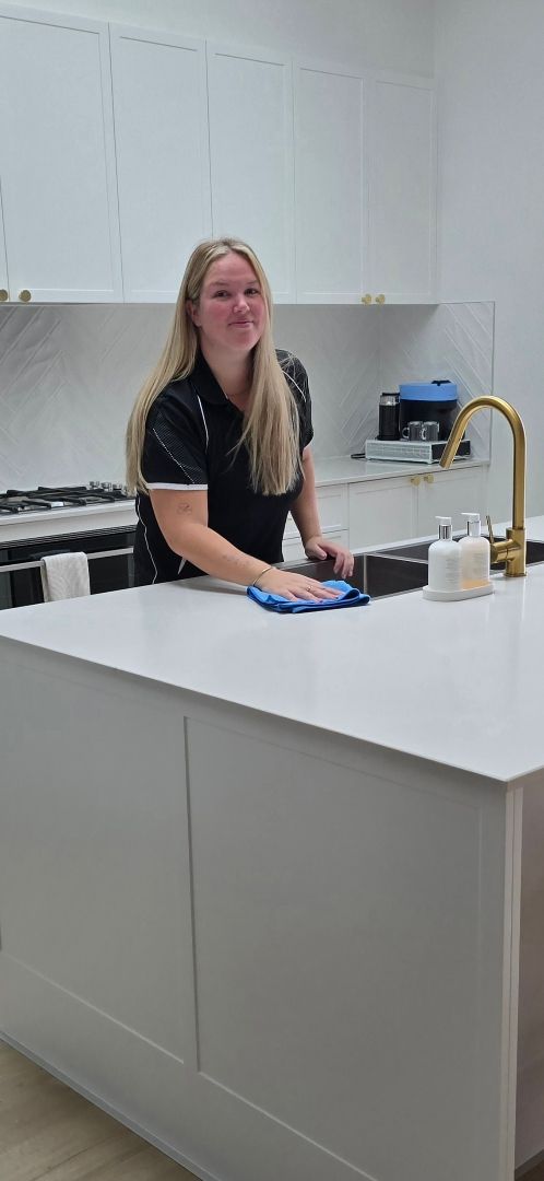 A Kitchen With White Cabinets and a Blue Backsplash — A Place 2 Shine In Chisholm, NSW
