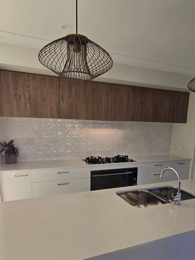 A Kitchen With White Cabinets and a Stainless Steel Sink — A Place 2 Shine In Chisholm, NSW