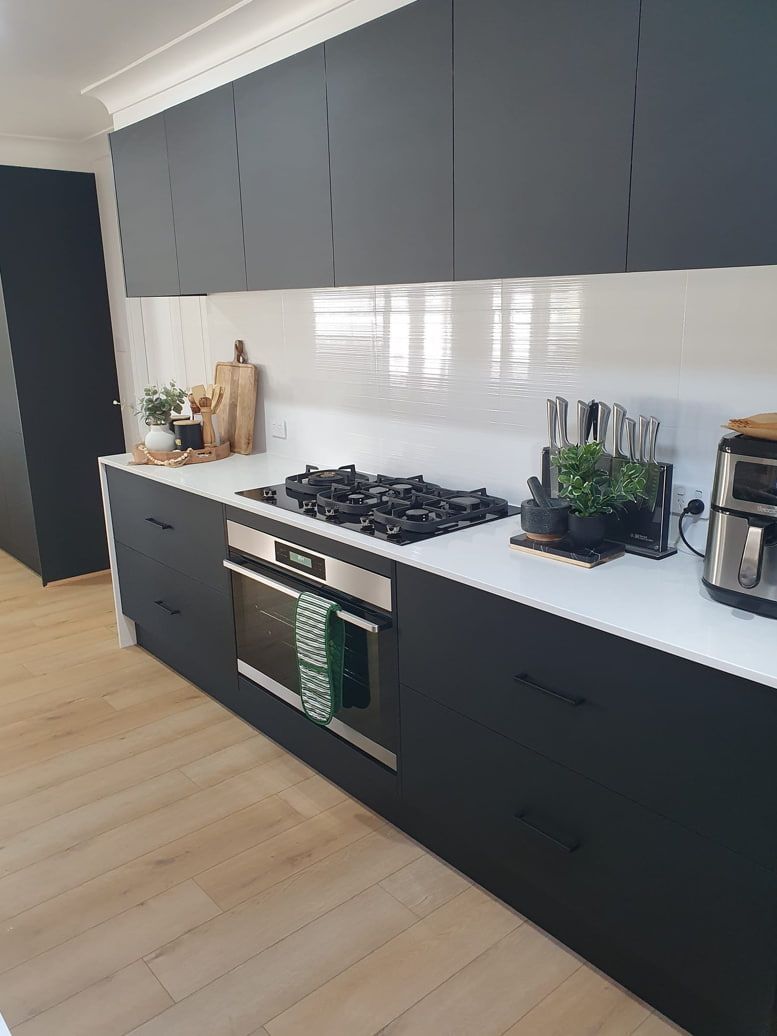 A Kitchen With Black Cabinets and White Counter Tops — A Place 2 Shine In Chisholm, NSW