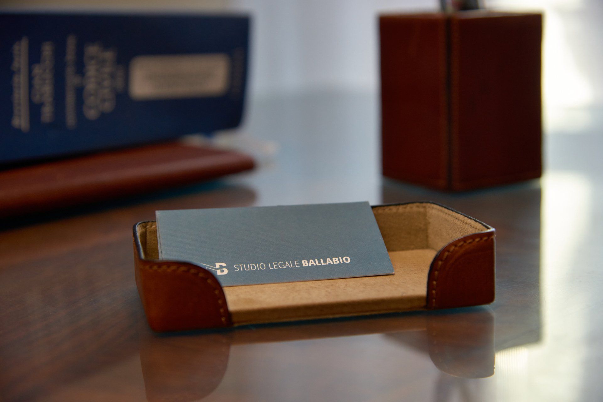 Porta biglietti da visita in pelle con un biglietto da visita su una scrivania.