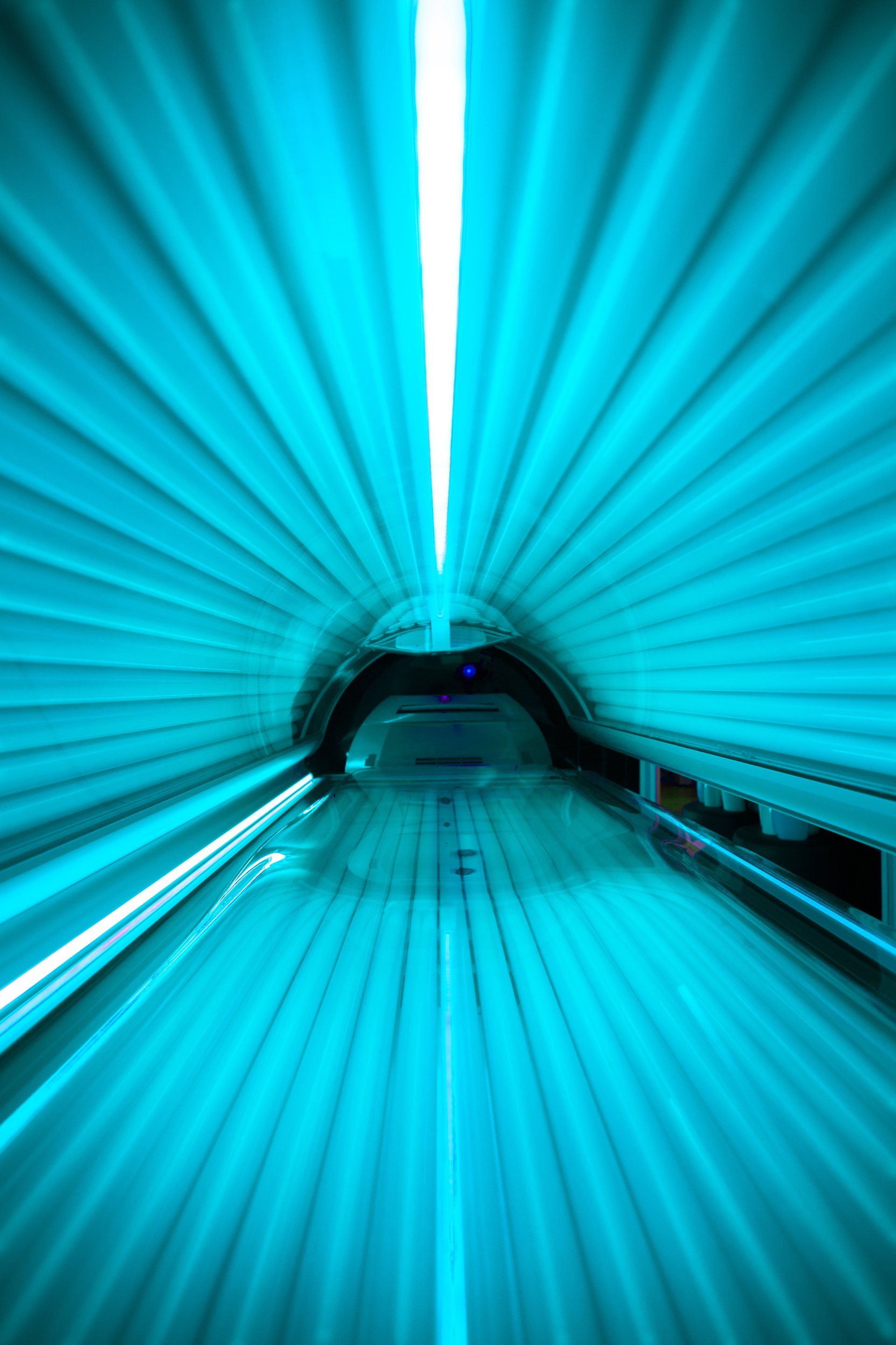 Un lit de bronzage avec des lumières bleues qui en sortent.