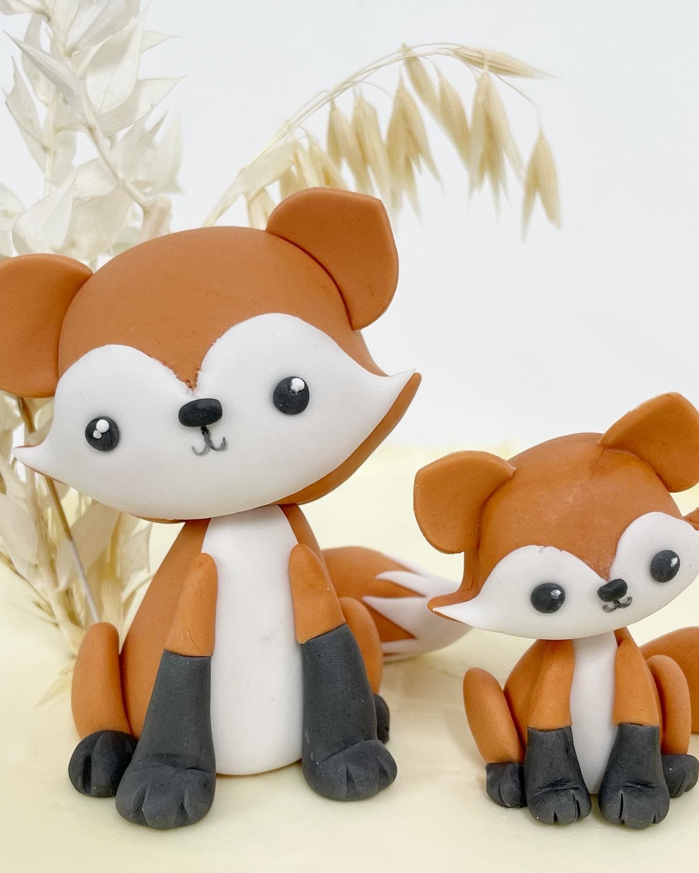 Two stuffed foxes are sitting next to each other on a table
