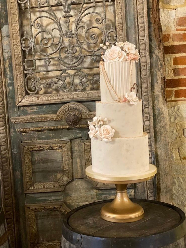A wedding cake is sitting on top of a wooden barrel.
