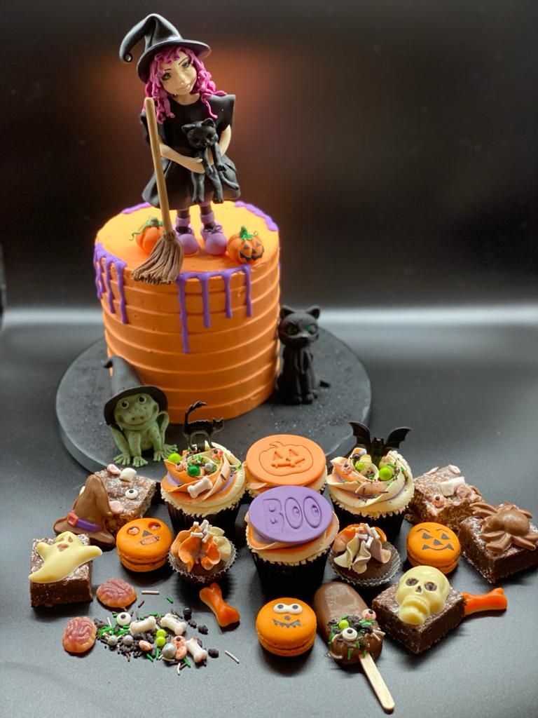A halloween cake with a witch on top of it