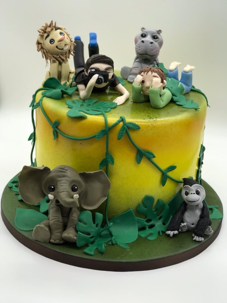 A yellow cake with animals on top of it.