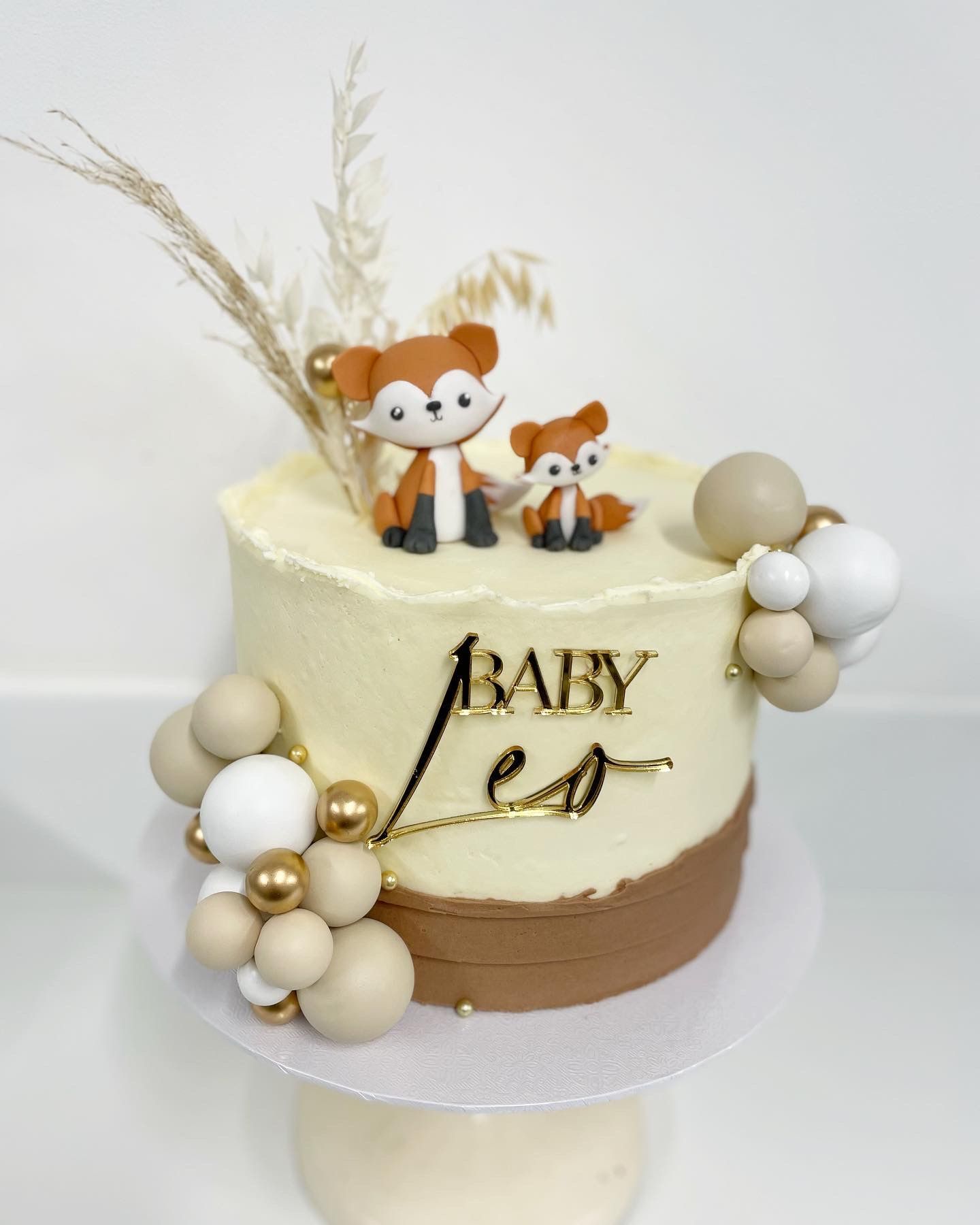 A baby leo cake with two foxes on top